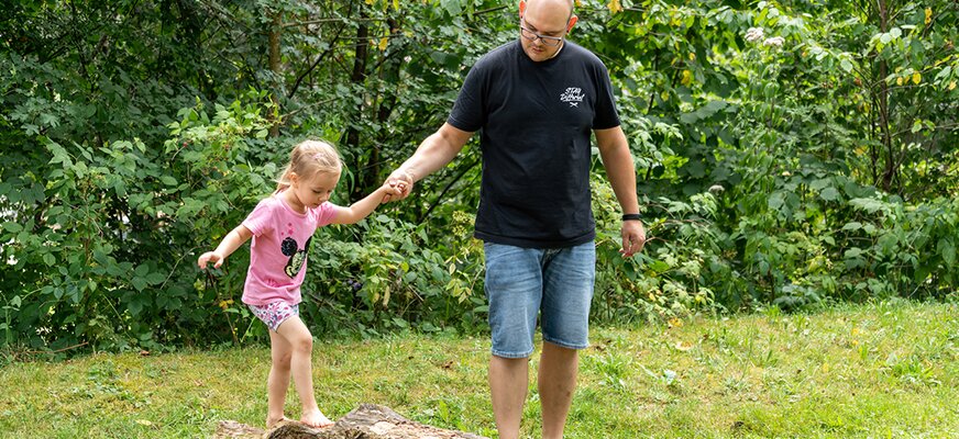 Vater mit Tochter beim Spazieren am Bach